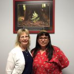 dr lopez with a woman under the determination poster in the clinic, weight loss and wellness solutions, san antonio texas