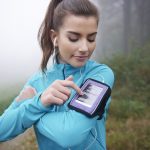 woman getting ready for her run by selecting something on her iphone, weight loss and wellness solutions, san antonio texas